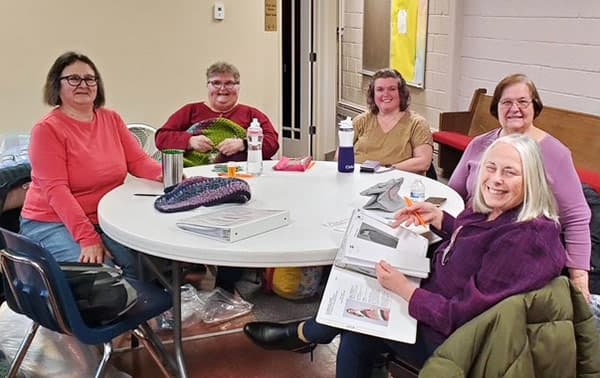 Threads of Compassion volunteers sitting at a table.